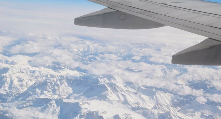 imagem de uma asa de avião com montanhas em baixo com a legenda "problemas em viagem"