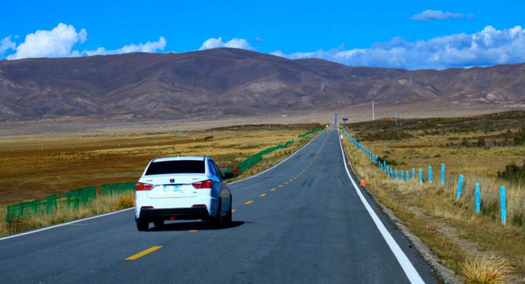 Imagem de um carro na estrada para ilustrar a postagem de revisões pré-pagas