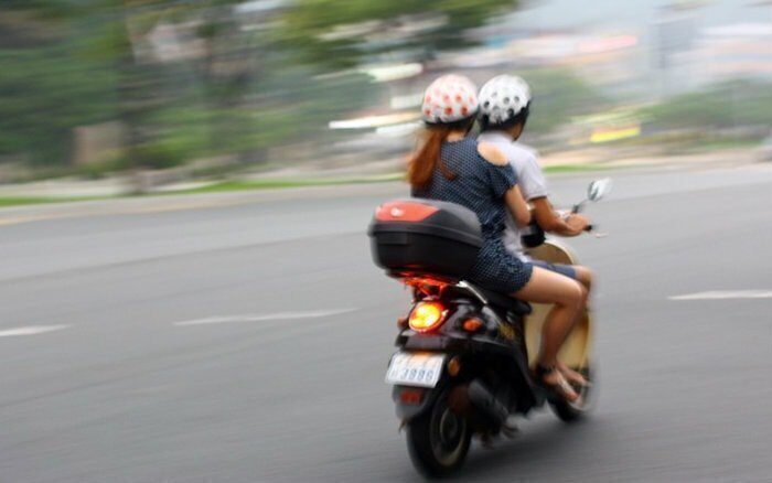 duas pessoas na moto com capacete ilustrando o post sobre carona sem capacete como emplacar moto