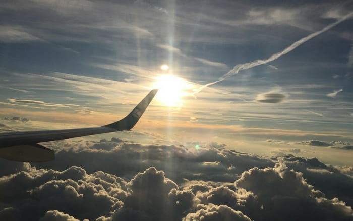 Imagem de avião entre as nuvens para ilustrar post sobre o que é booking