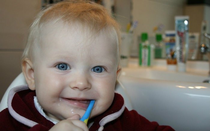 Imagem de bebê escovando os dentes para ilustrar texto sobre Fluorose