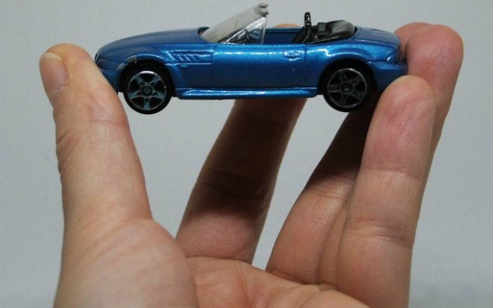 Imagem de carro miniatura na mão de uma pessoa para ilustrar texto sobre seguro temporário