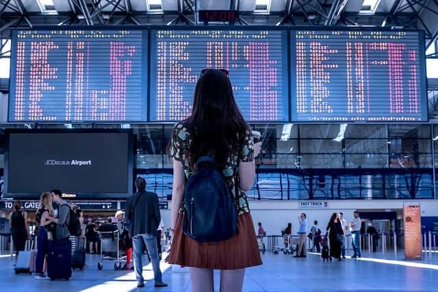 Imagem de uma mulher no aeroporto para ilustrar a postagem de Roupas para viajar de avião.