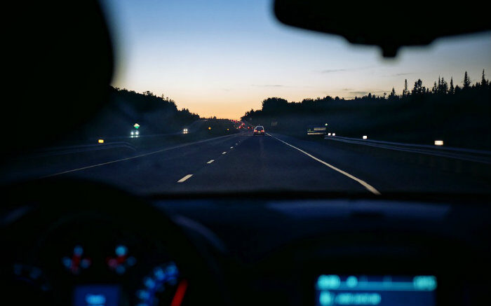 Foto de carro em estrada para texto sobre seguro viagem para aluguel de carro